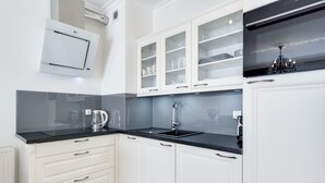 A modern kitchen with white cabinets, a black countertop, and a built-in oven.