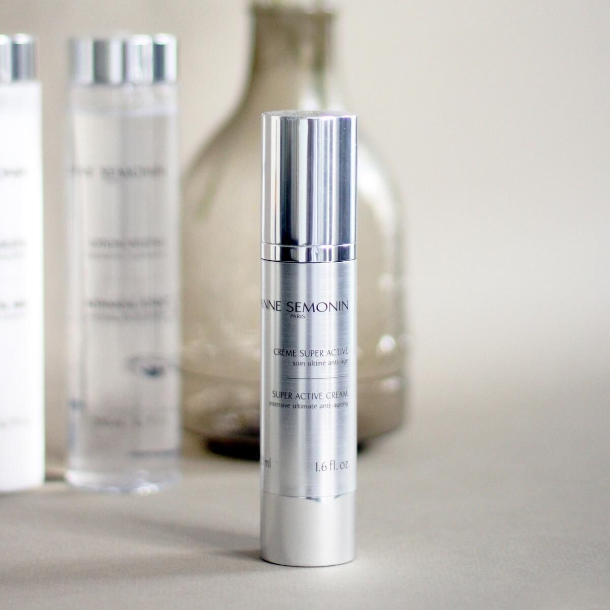 A skincare product with a metallic finish and a volume of 1.6 fl. oz.