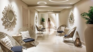 A hallway with wicker chairs, a large mirror, and a plant.