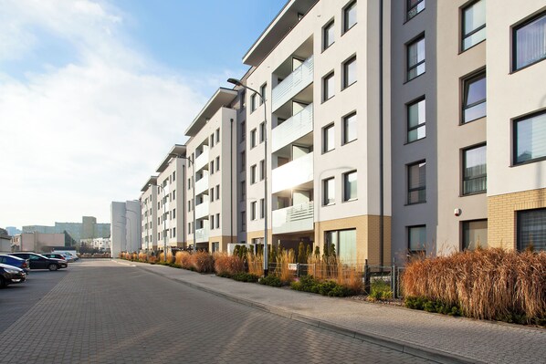 A modern apartment building with multiple floors, balconies, and a paved street in front. - Elite Apartments Marine Suite (Gdansk)