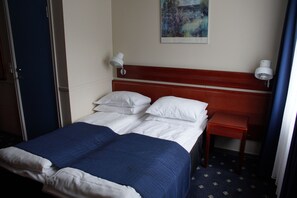 A hotel room with a bed, two bedside lamps, a small table, and a painting on the wall. - Welcome Inn Hotel Lyngskroa (Storfjord)