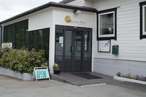 A hotel entrance with a sign reading "Welcome Inn Hotel Lyngsbroa" and a signboard indicating the establishment is open. - Welcome Inn Hotel Lyngskroa (Storfjord)