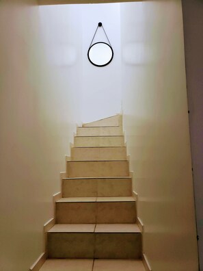 A staircase with a circular light fixture above it.