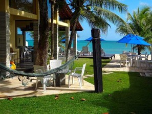A beachside lounge with outdoor seating, a hammock, and a view of the ocean. - Pousada Santo Aleixo (Ipojuca)