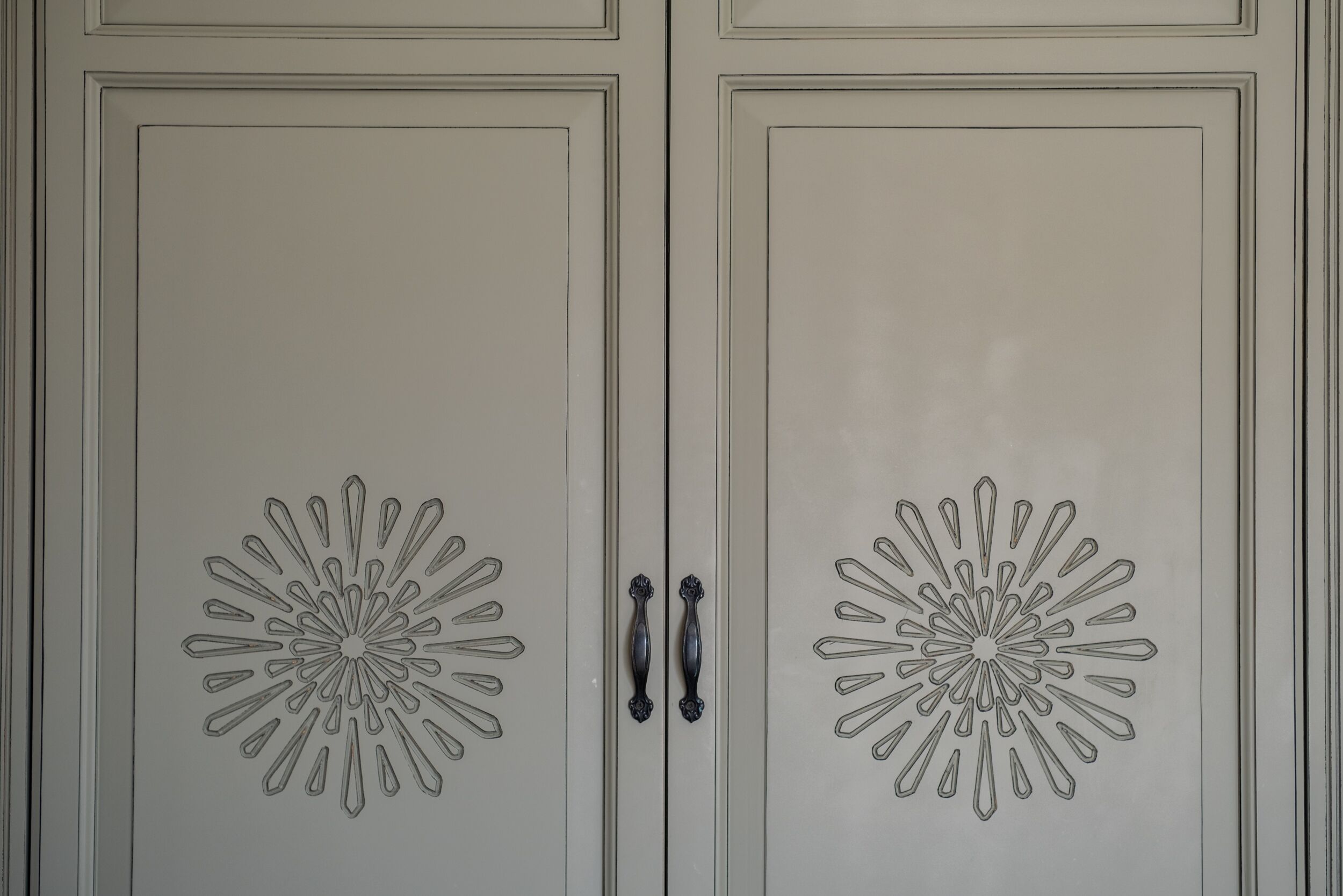 A set of double doors with symmetrical, geometric patterns and central handles.