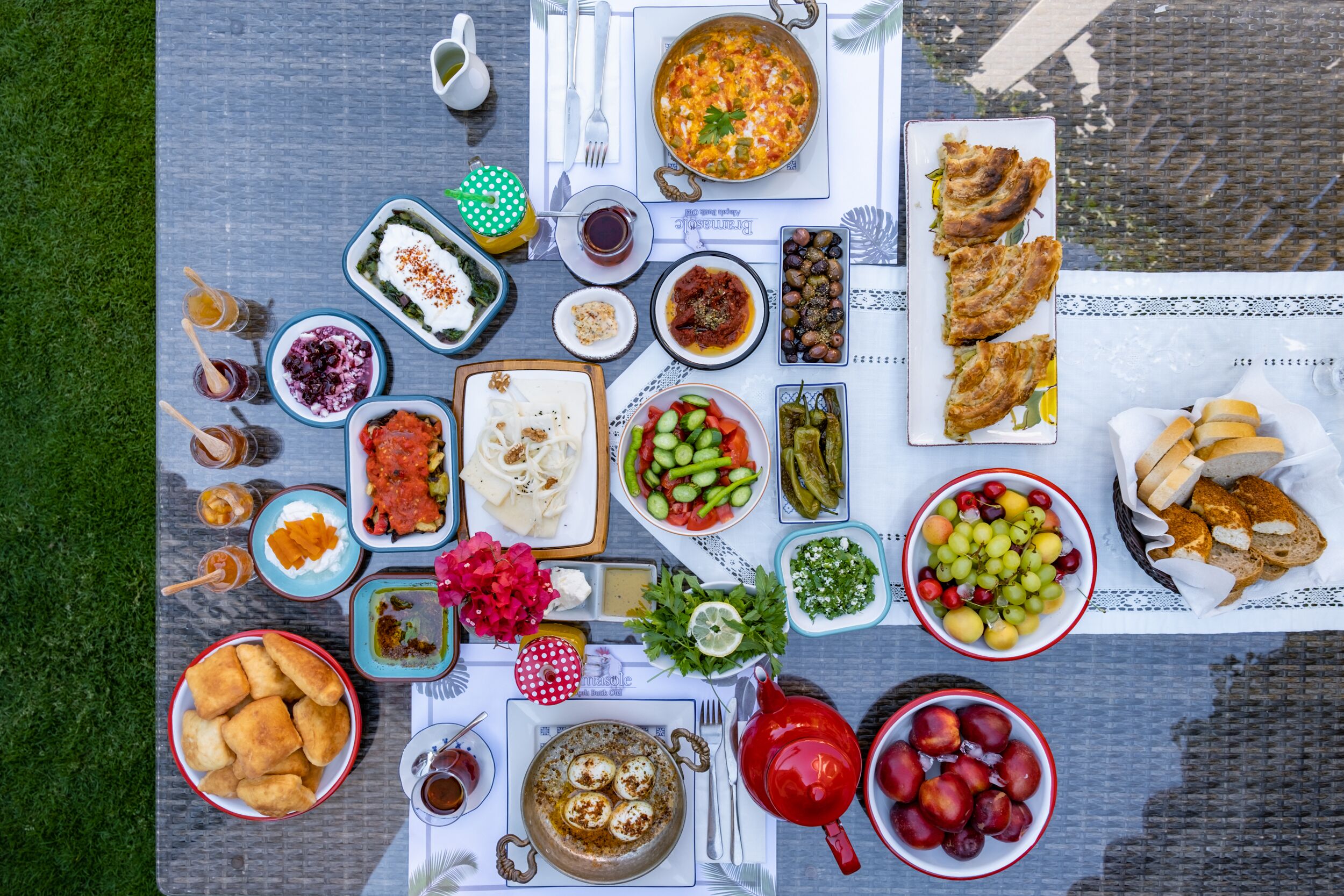 A table set with various dishes, including a large pot, bowls of food, and a plate of bread.