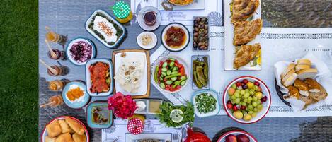 A table set with various dishes, including a large pot, bowls of food, and a plate of bread.