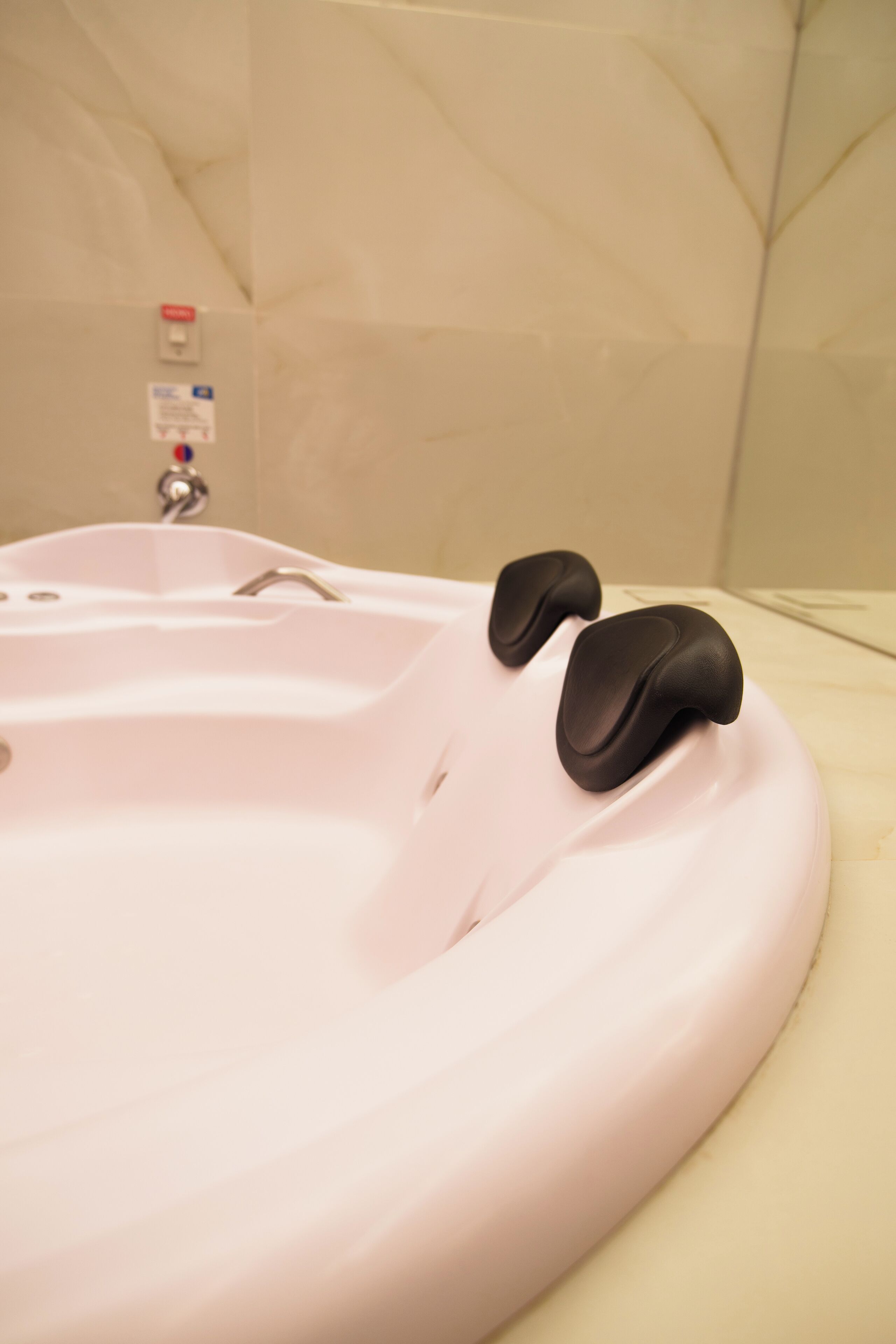 A bathroom with a bathtub, a faucet, and a control panel.