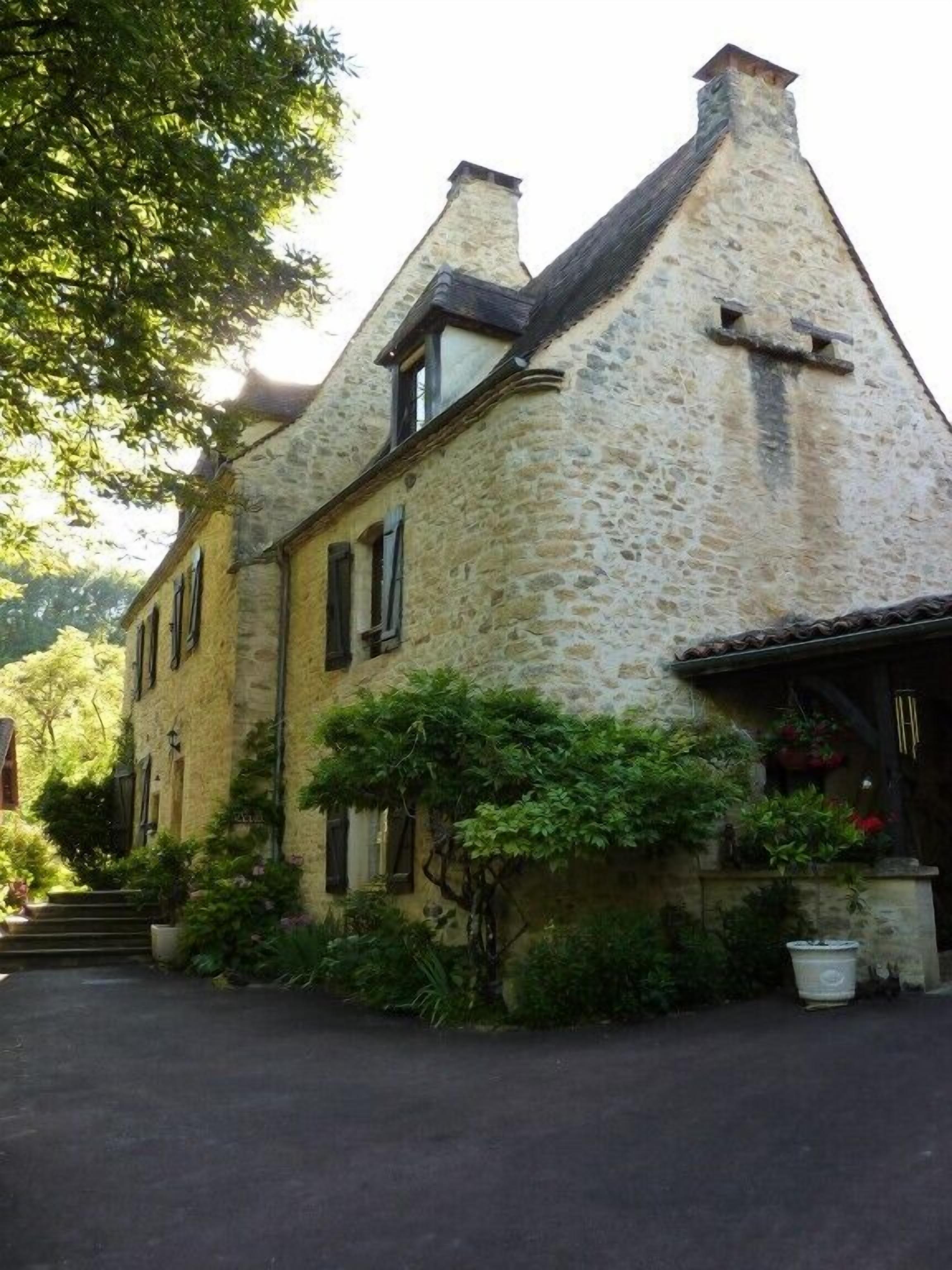 Un bâtiment en pierre doté d’un toit à forte pente, d’une petite fenêtre et d’une porte avec un cadre en bois.