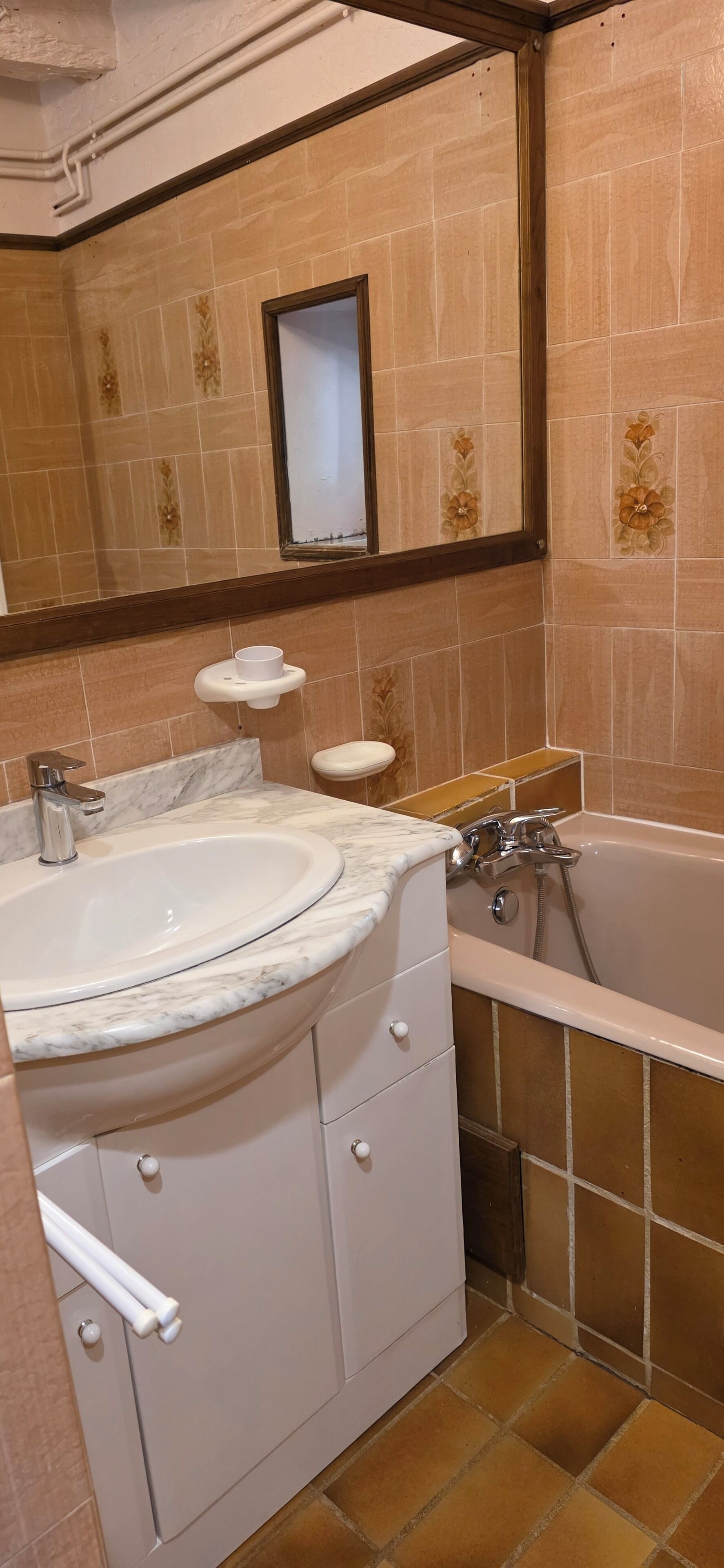 Un baño con lavabo, espejo, inodoro y bañera.