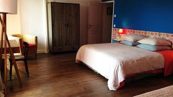 Une chambre à coucher avec un lit, une armoire, une chaise et une lampe.