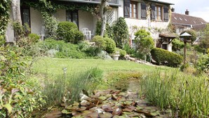A house with a garden, a pond with lily pads, and a small stream. - La Maréchalerie (Monthodon)