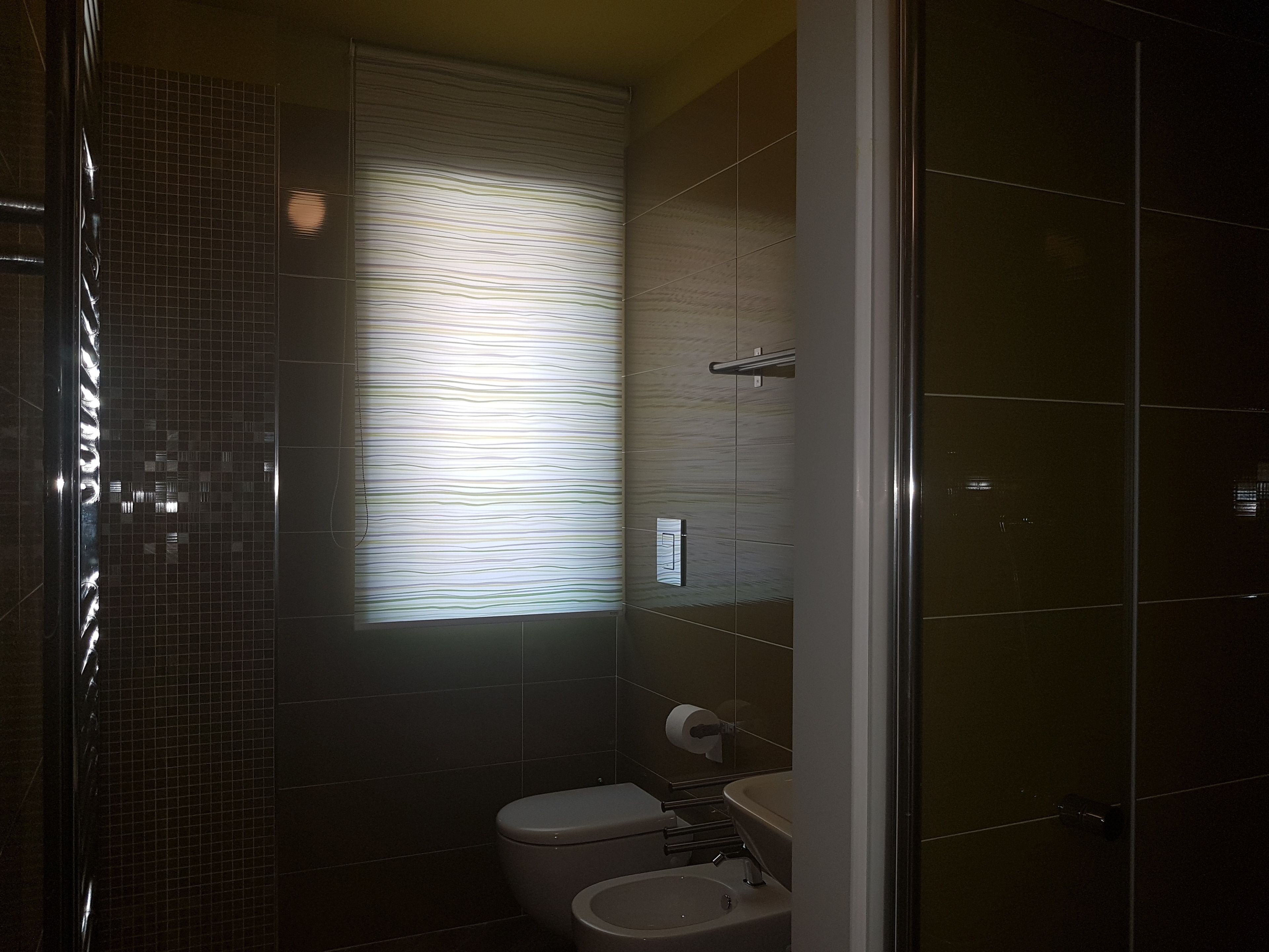 Un baño con inodoro, lavamanos y zona de ducha.
