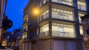 A multi-story residential building with balconies, a garage, and a street view. - Palazzo Ducale (San Severo)