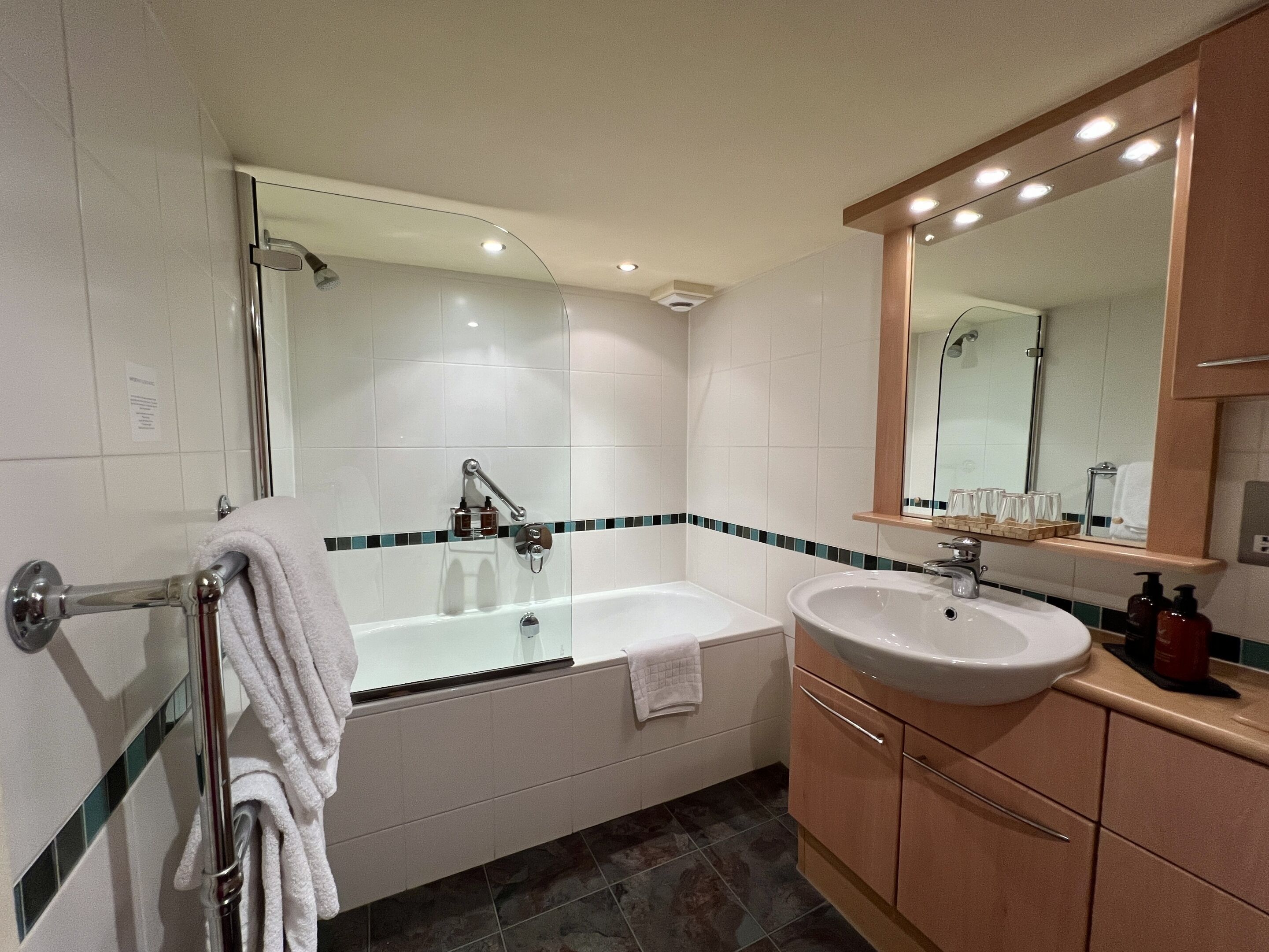 Ein modernes Badezimmer mit einer Badewanne, einem Waschbecken und einem Spiegel.