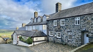 A stone building with a sign reading "Castle Cottage." - Castle Cottage Inn (Harlech)