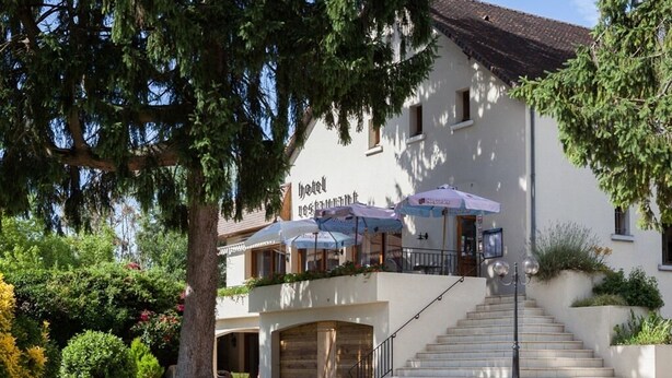 A hotel with a staircase leading to the entrance, outdoor umbrellas, and a well-maintained garden. - Hôtel Restaurant La Bonne Etape (Amboise)