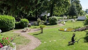 A well-maintained garden with a paved path, a small pond, and a picnic table. - Hôtel Restaurant La Bonne Etape (Amboise)