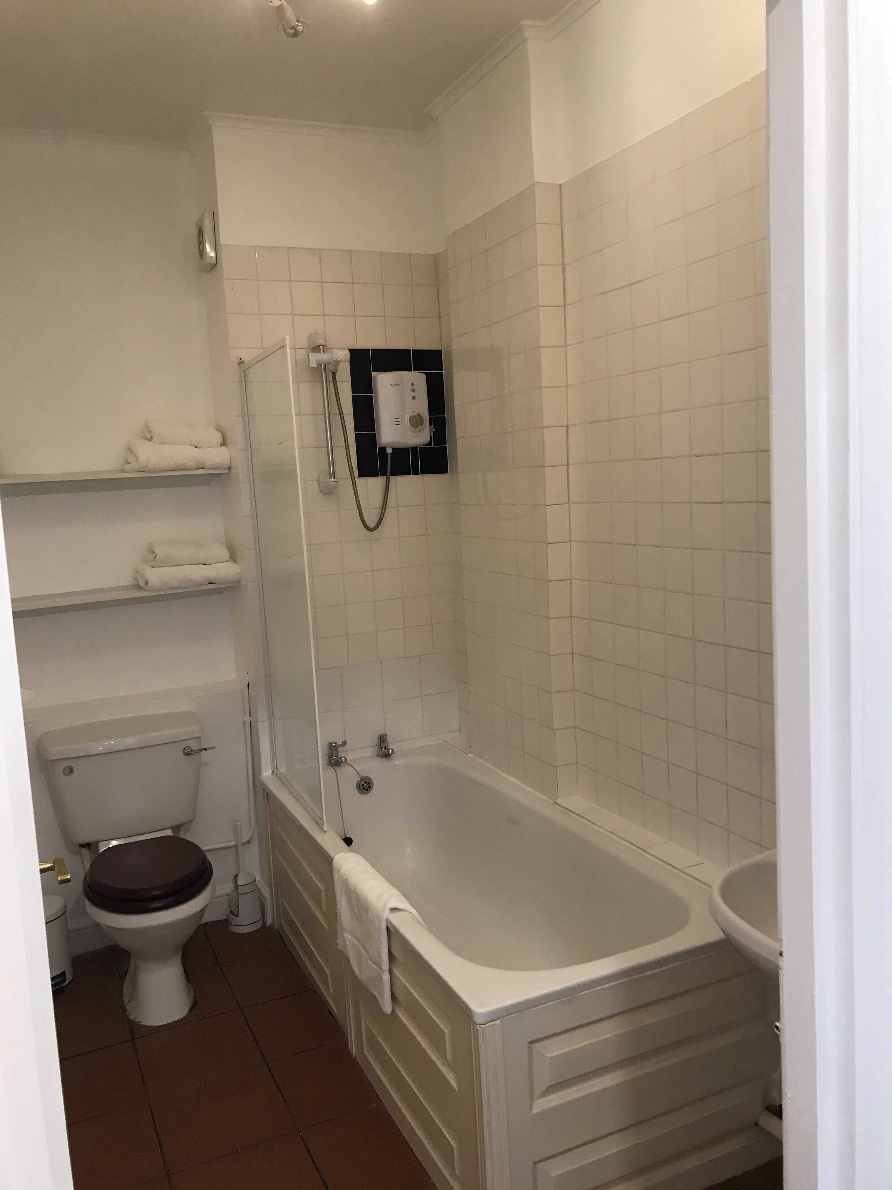 Une salle de bain comprenant des toilettes, une baignoire et un espace douche.