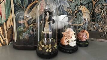 A display of glass domes with various objects inside, including shells and figurines, set against a patterned backdrop.