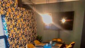 Un comedor con una larga mesa de madera, seis sillas y un papel tapiz estampado.