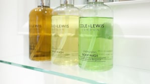 Three bottles of hand wash and body wash on a glass shelf. - The Willow Restaurant B&B (Harrogate)