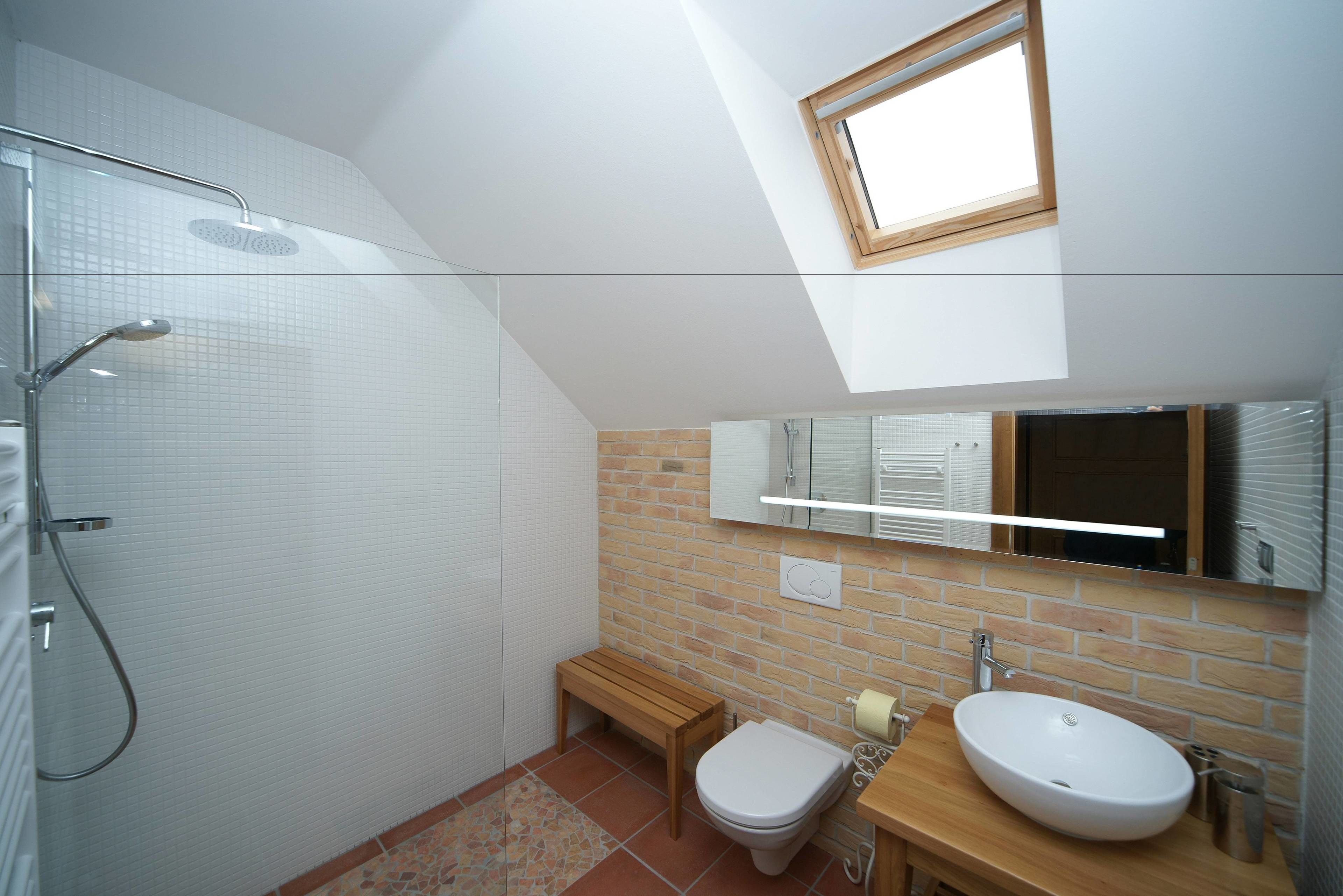 A modern bathroom with a shower, toilet, and sink.