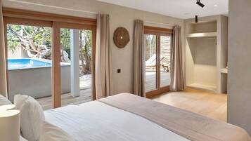 A bedroom with a large bed, a walk-in closet, and a sliding glass door leading to a pool area.