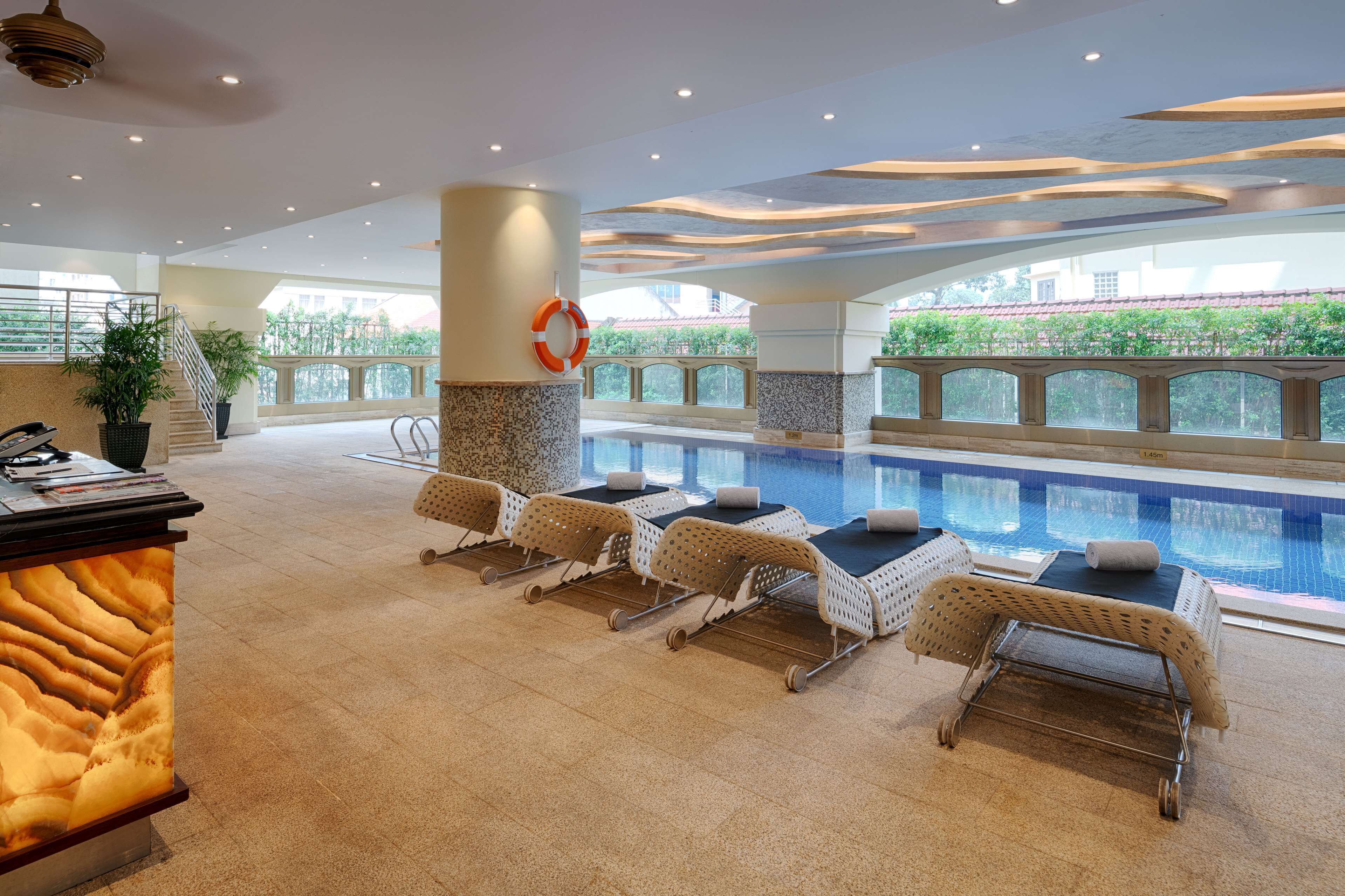 A poolside area with lounge chairs and a reception desk.