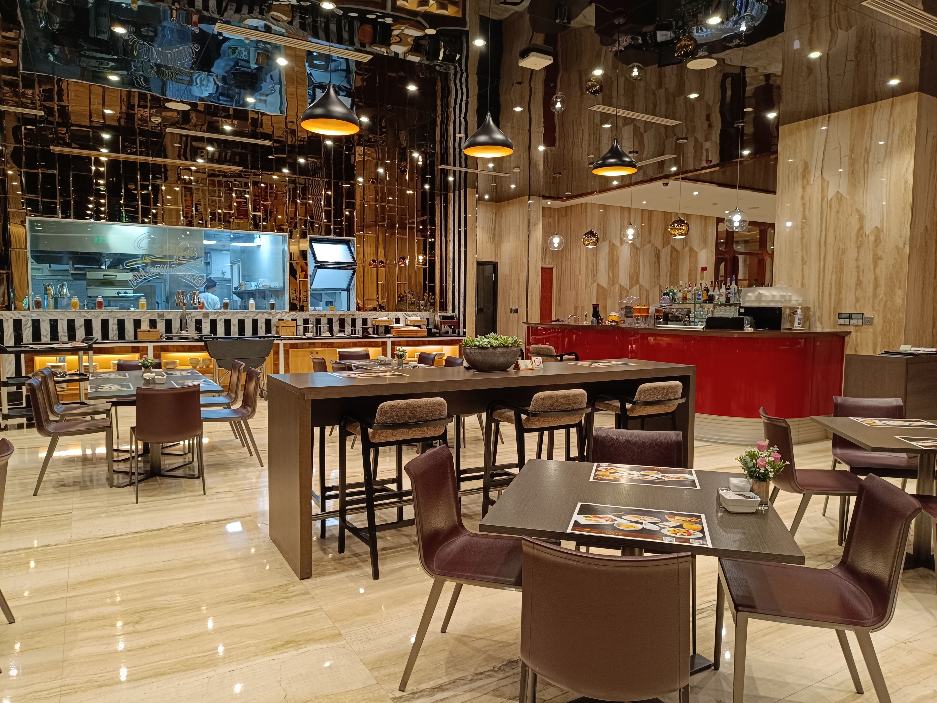 Un restaurant moderne doté d’un bar, de touches de bois et d’un éclairage contemporain.
