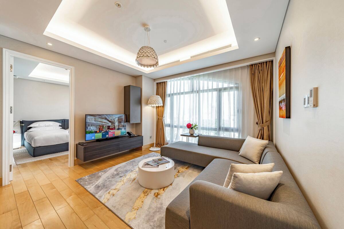 Een moderne hotelkamer met een groot bed, een bank, een televisie en een eethoek.