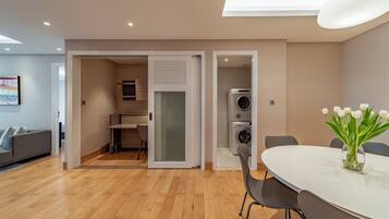 A modern apartment with a dining area, a kitchen, and a laundry room.