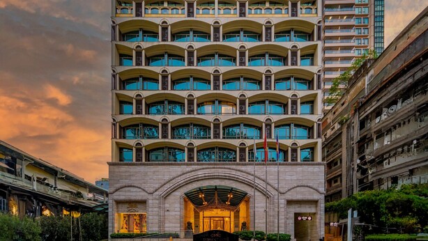 Een hotel met meerdere verdiepingen, een opvallende gebogen gevel en tal van balkons.