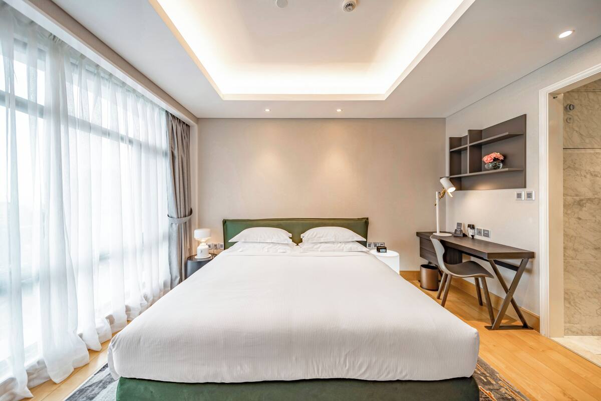 Een moderne hotelkamer met een groot bed, een bureau en een stoel.