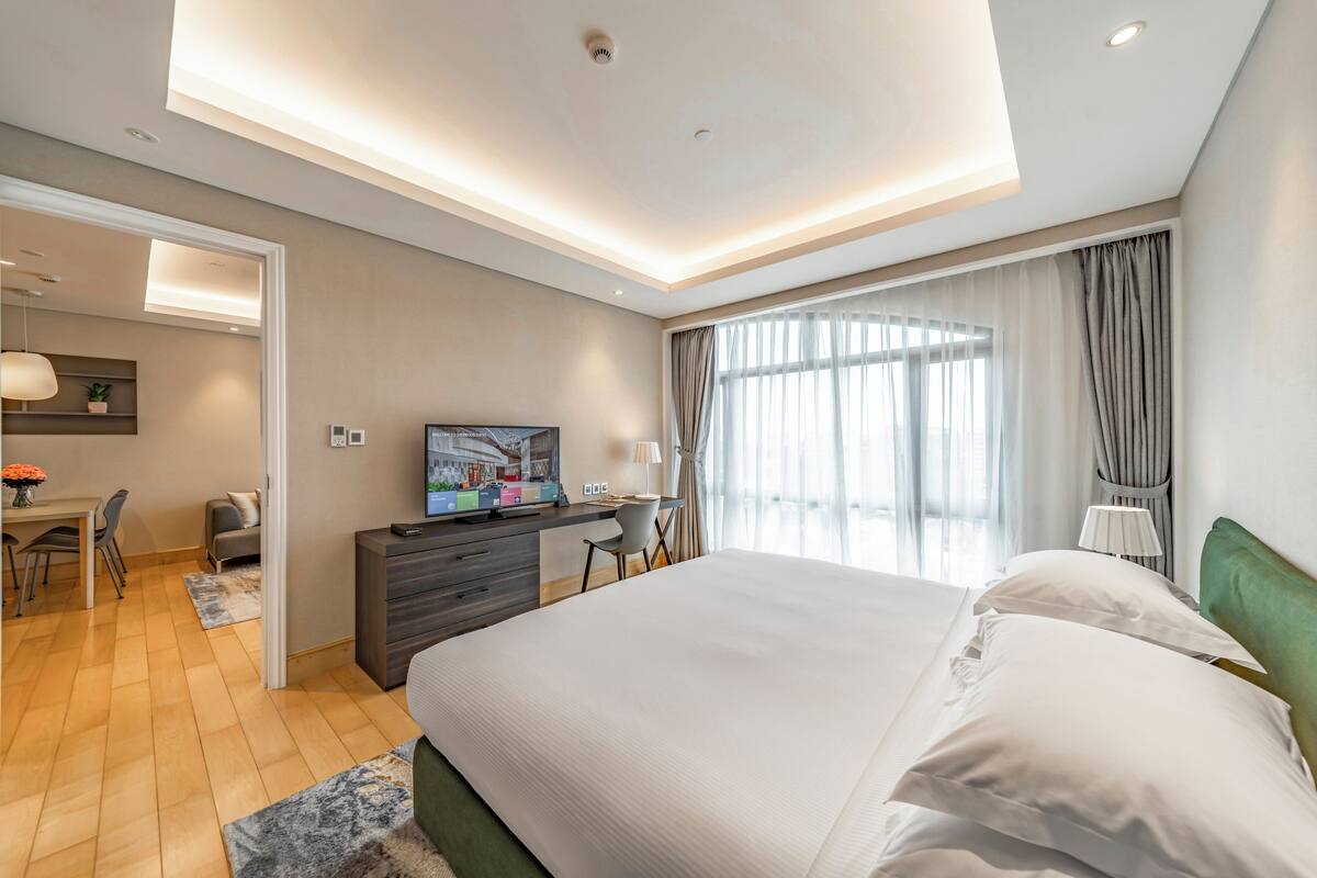 Een moderne hotelkamer met een groot bed, een bureau en een televisie.