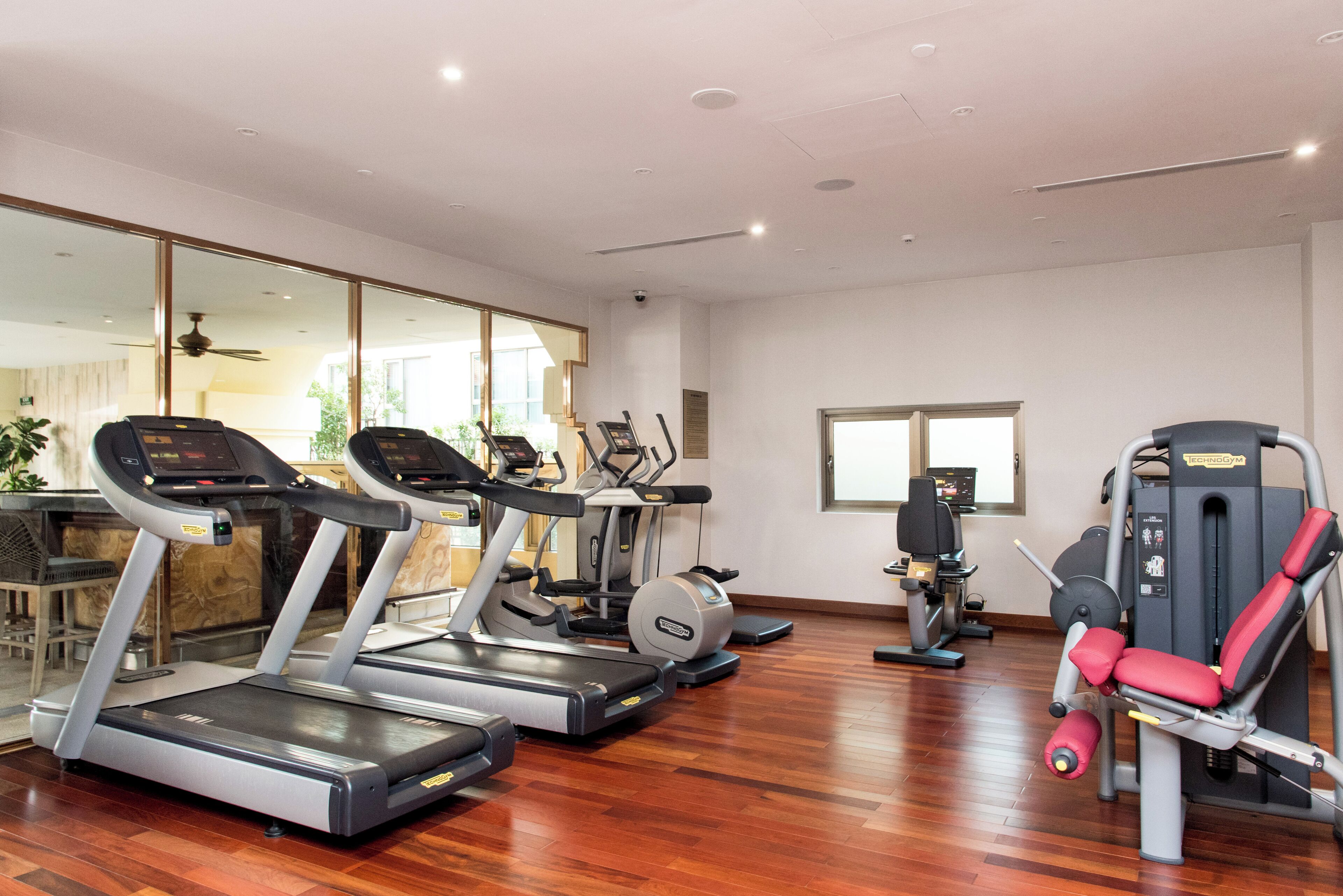 Une salle de sport équipée de tapis de course, de vélos elliptiques et de matériel de musculation.
