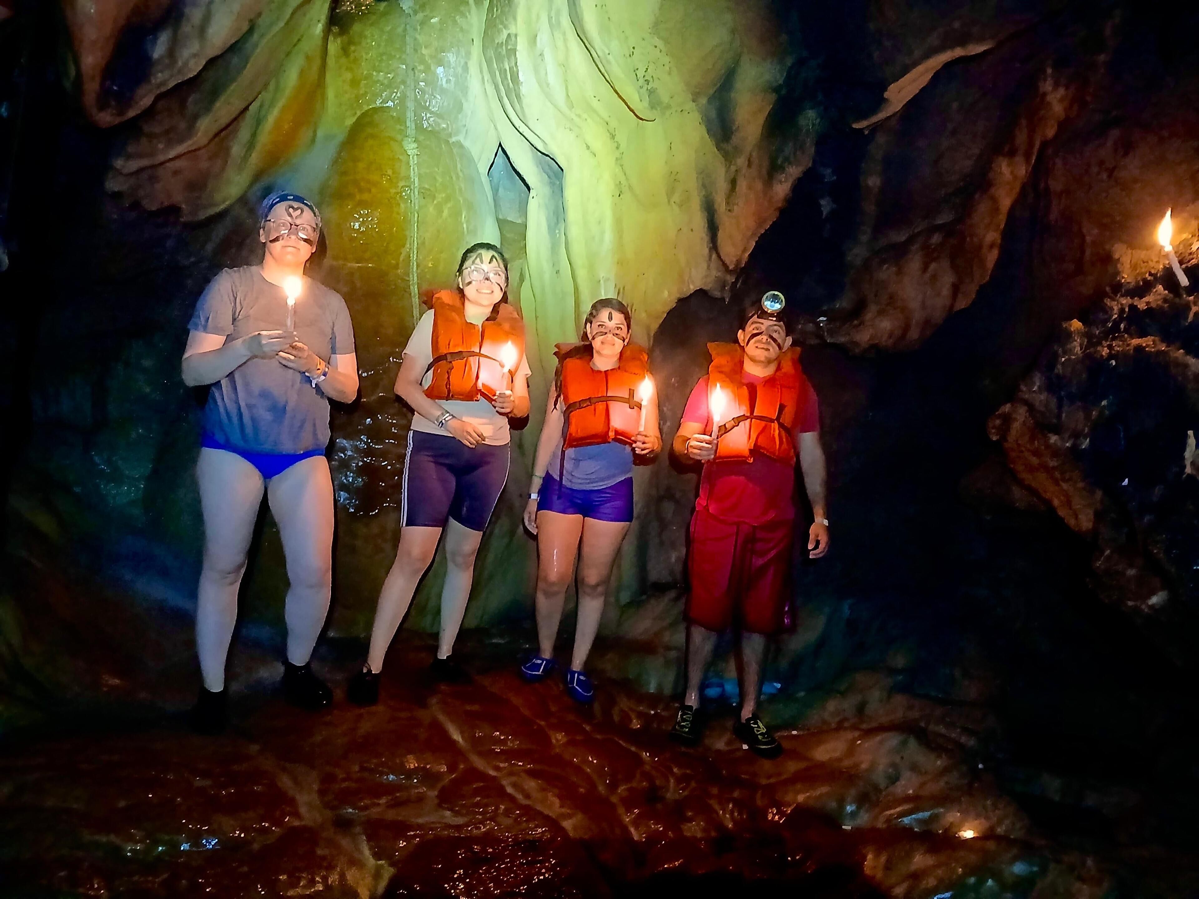 Un grupo de personas en una cueva con iluminación artificial.