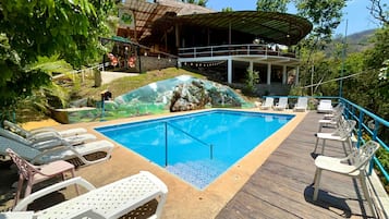 A swimming pool with lounge chairs and a deck area.