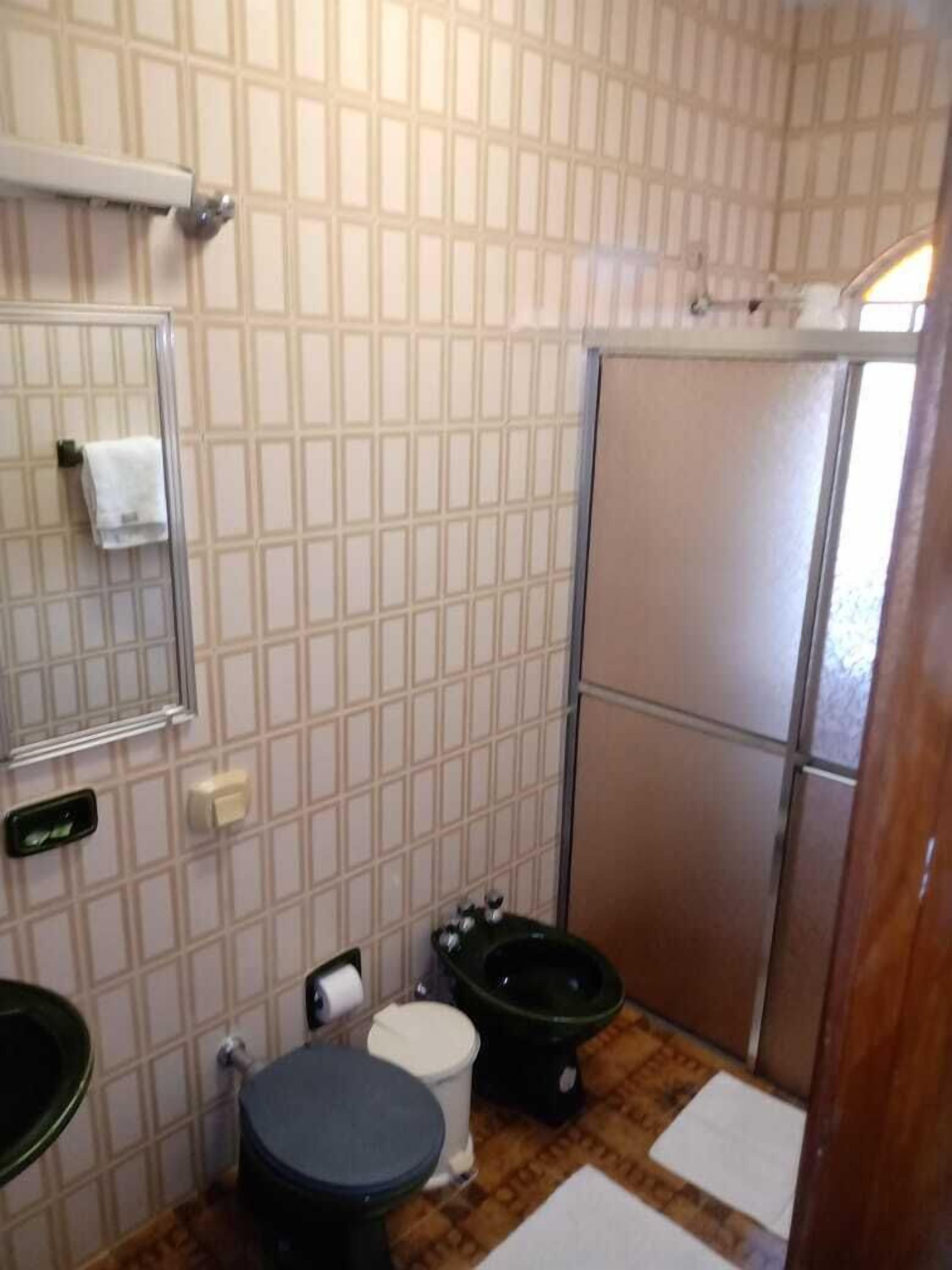 Un baño pequeño con inodoro, bidé y lavamanos.