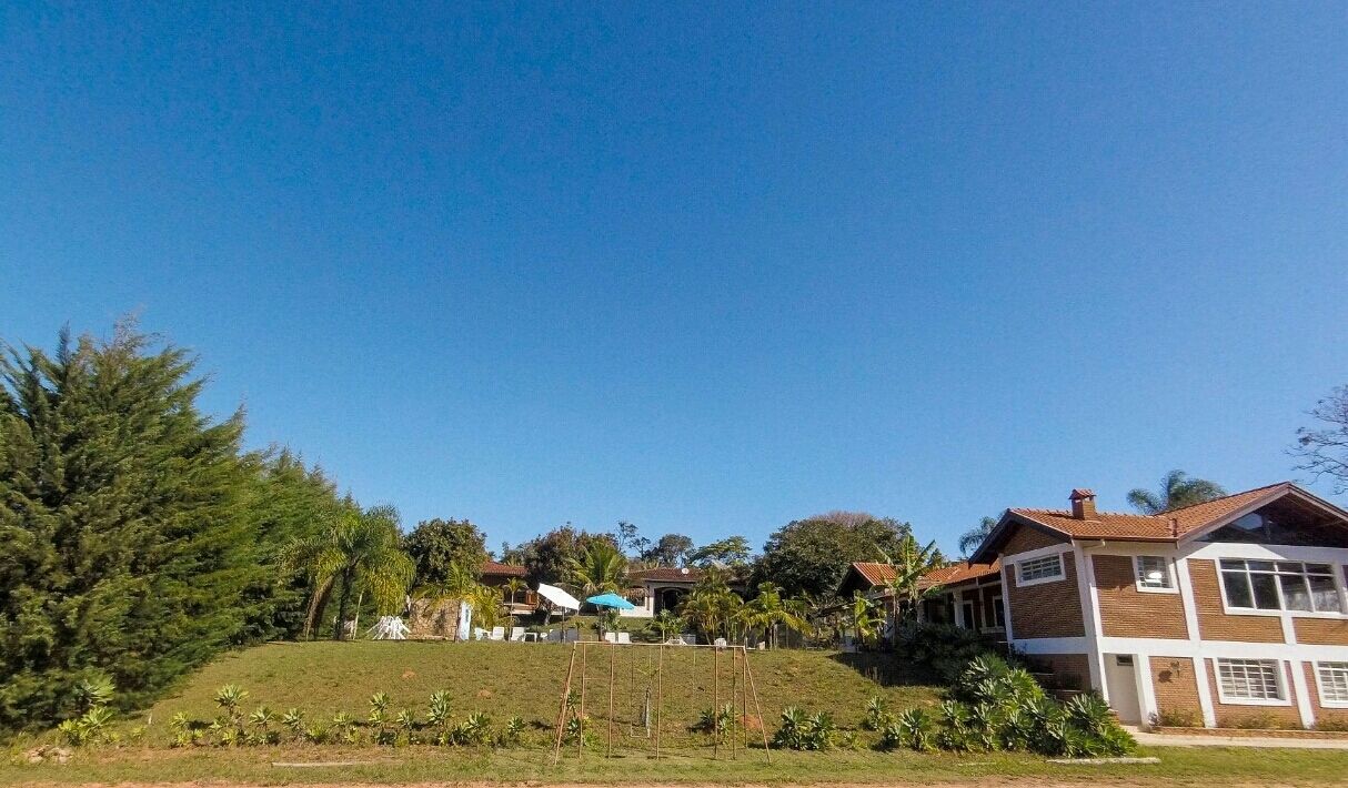A residential area with houses, a grassy hill, and trees.