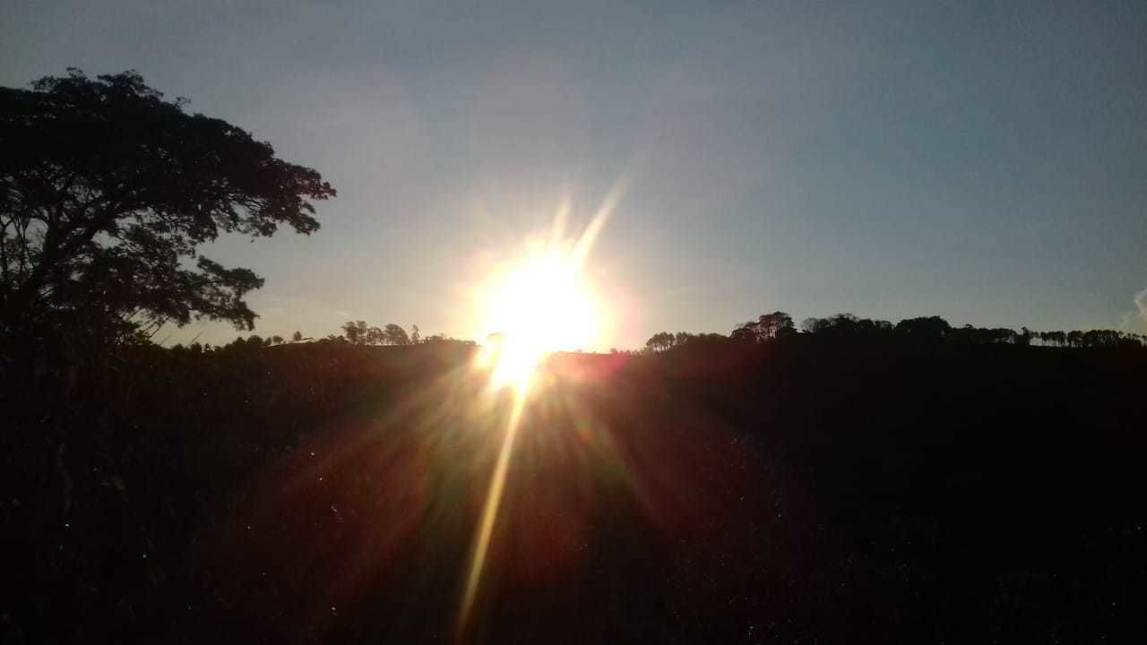 Ein Sonnenuntergang mit tiefstehender Sonne am Horizont, der einen hellen Schein und einen Lens-Flare-Effekt erzeugt.