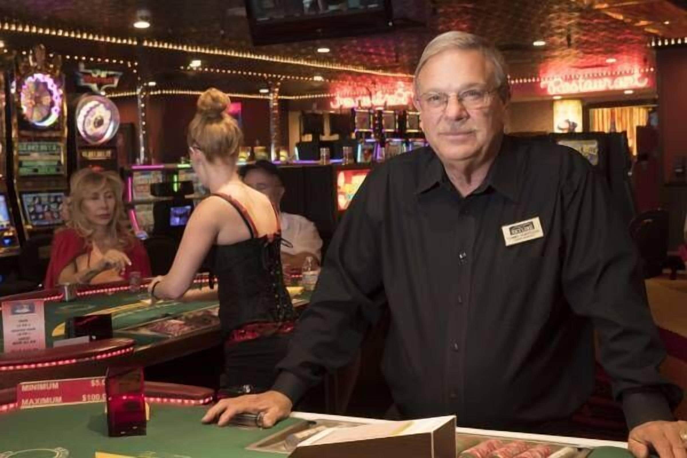 Un casino comprenant des tables de jeux, des machines à sous et un bar.