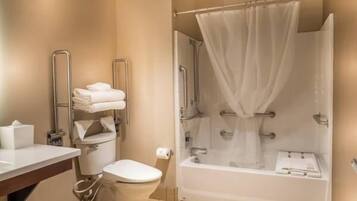 A bathroom with a toilet, a sink, a shower with a curtain, and a bathtub.