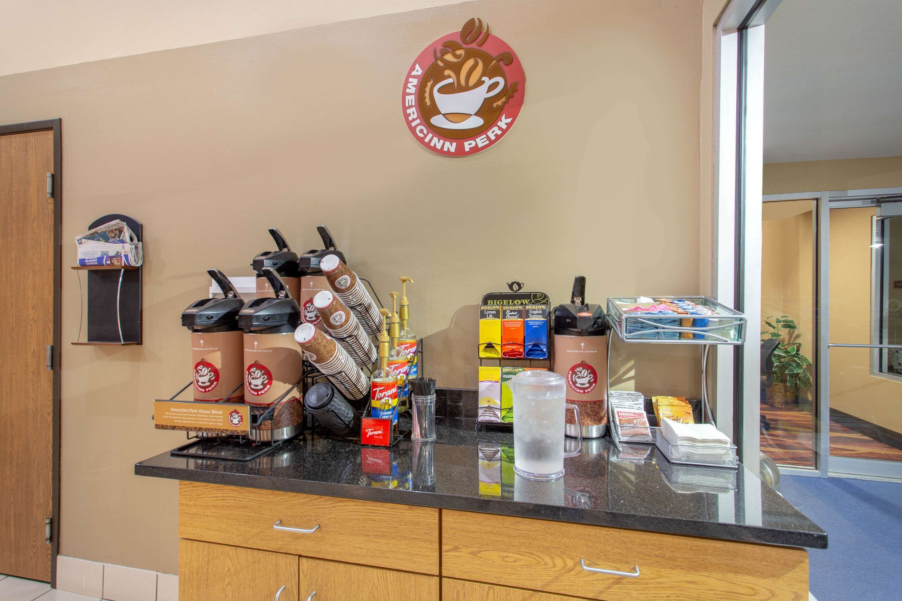 A coffee station with a coffee machine, cups, and a coffee bag.