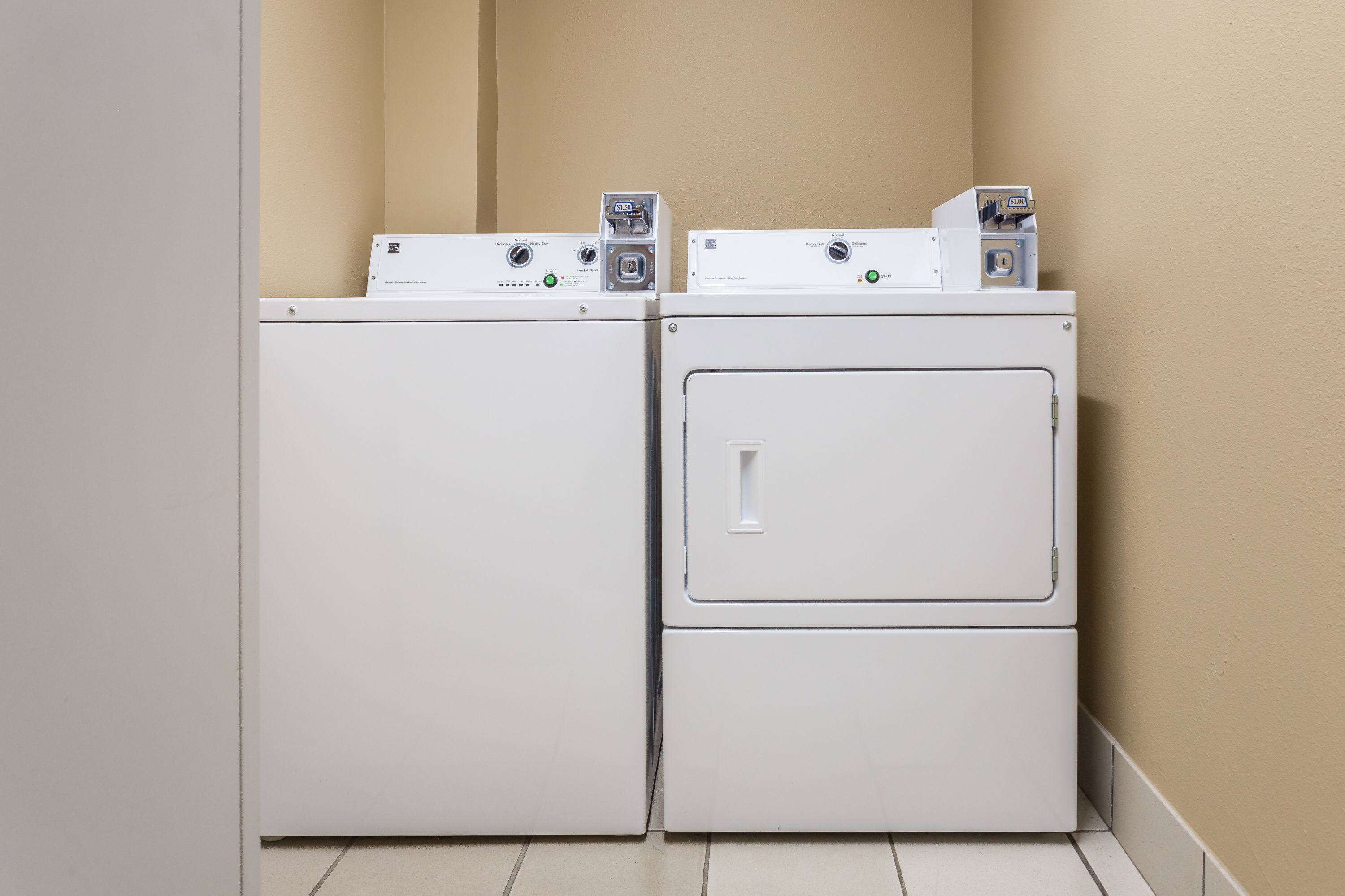 A laundry room with two stacked washers and dryers.