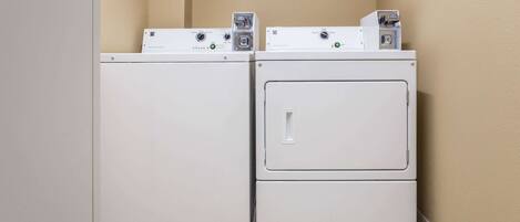A laundry room with two stacked washers and dryers.