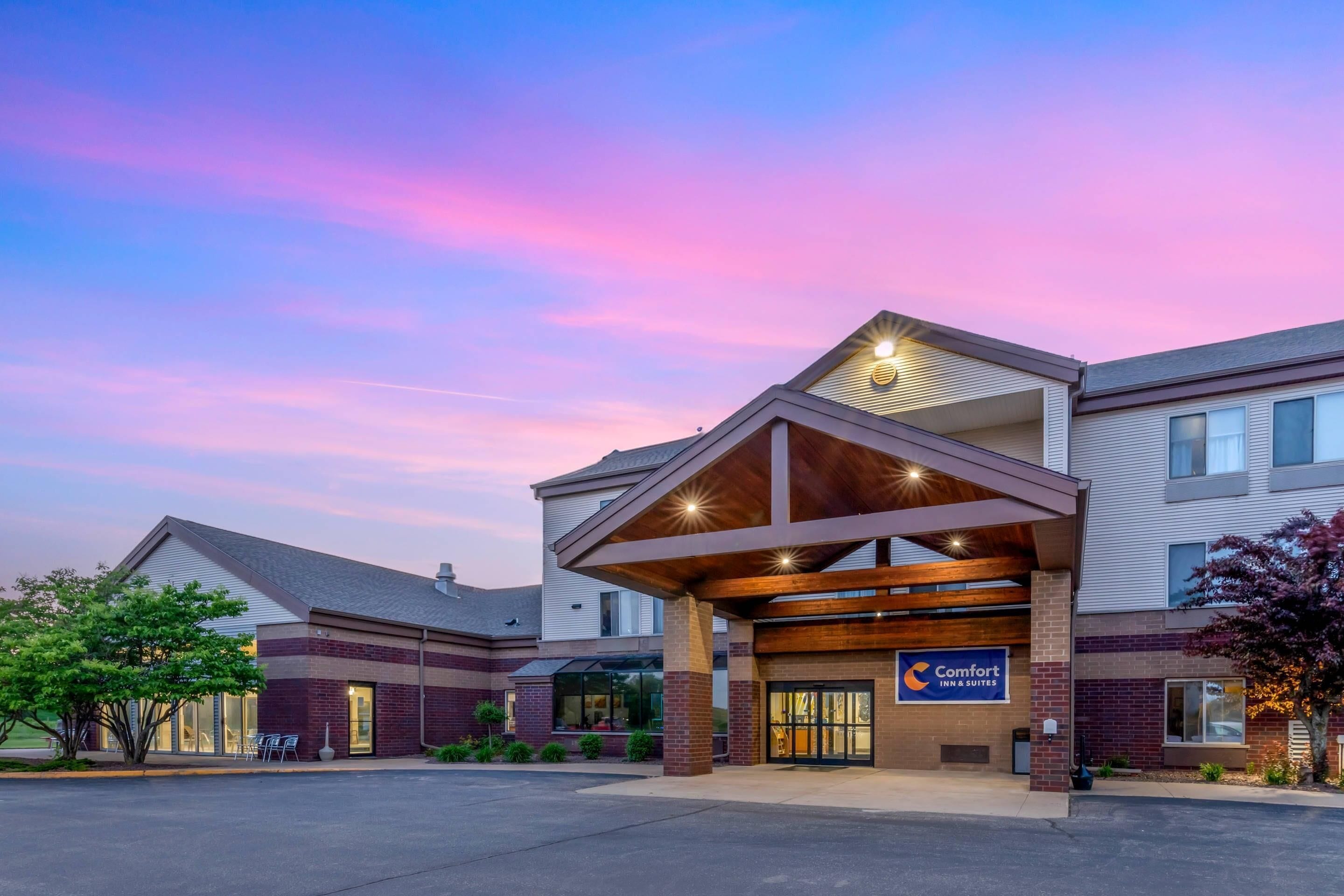 A Comfort Inn & Suites hotel with a modern design, featuring a covered entrance and a parking lot.