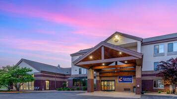 A Comfort Inn & Suites hotel with a modern design, featuring a covered entrance and a parking lot.