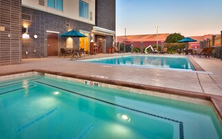 Una piscina con indicador de profundidad de 3 pies, sillas de descanso y una zona de estar cubierta.