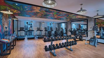 A gym with treadmills, elliptical machines, and free weights.